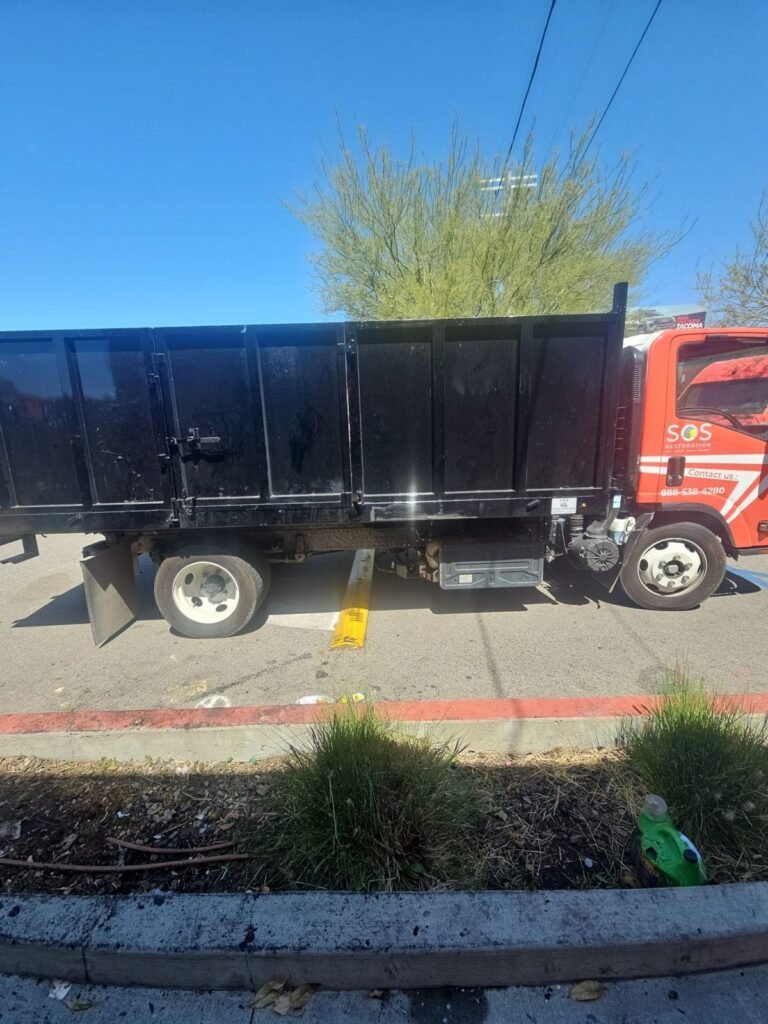 The SOS dump truck parked at the curb for debris removal in the East Bay