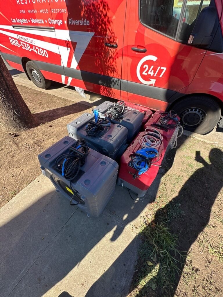 Tool cases and drying gear unloaded from the SOS van on a driveway in the East Bay