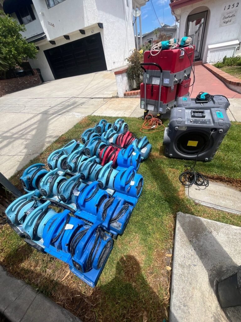 Rows of blue air movers staged on the lawn in front of a house in the East Bay