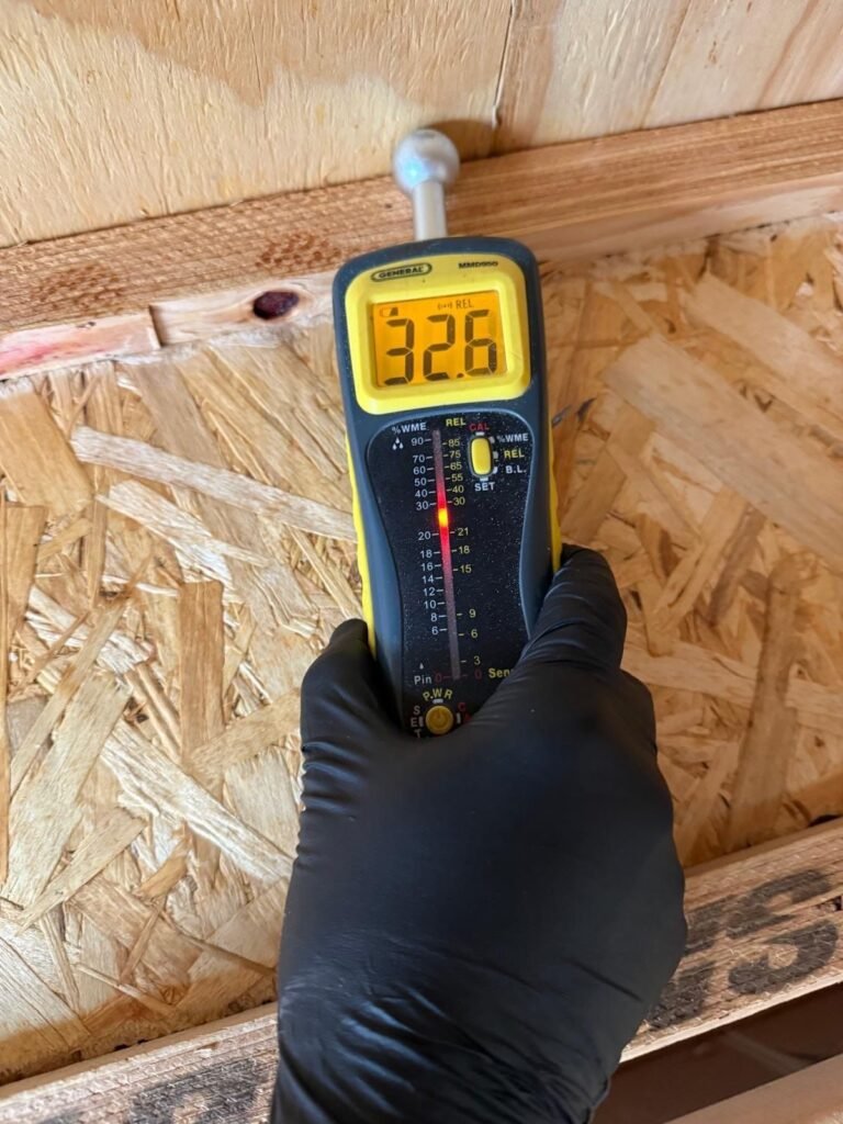 A moisture meter reading 32.6 against OSB subfloor in the East Bay