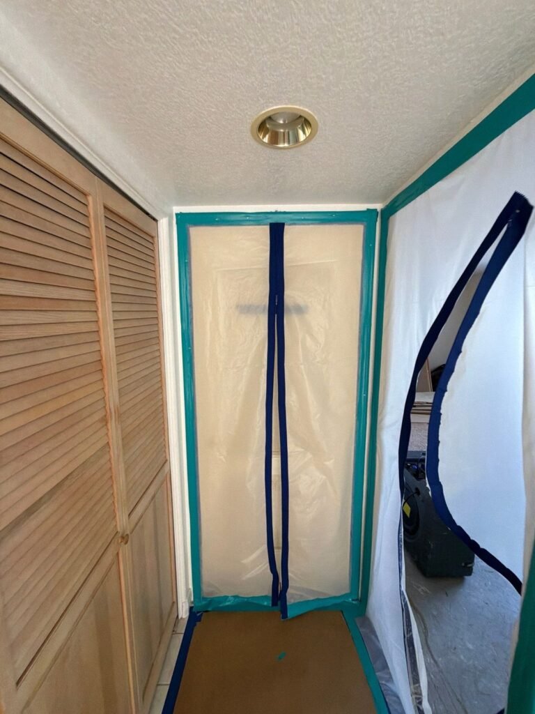 A containment barrier with a zipper door closing off a hallway in the East Bay
